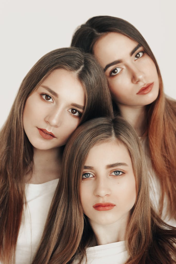 Sophisticated studio portrait of three young women embracing elegance and timeless beauty.
